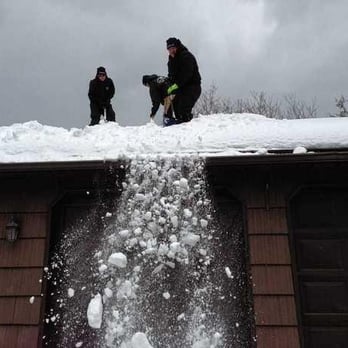 The Roofing Guys - The Roofing Guys hard at work removing snow off a house to help prevent ice dams. Photo courtesy of Syracuse.com - Roofing Near Me - Syracuse, New York
