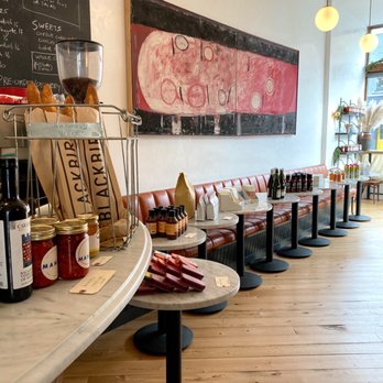 Manita - a row of tables with bottles of wine on them - Coffee & Tea Near Me - Toronto, Ontario
