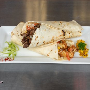 Global Grill - a burrito with meat and vegetables on a white plate - Mexican Near Me - Windsor Mill, Maryland Global Grill - a burrito with meat and vegetables on a white plate - Mexican Near Me - Windsor Mill, Maryland