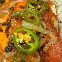 Wolfe Wagon - The mess- 1/4lb Beef hot dog wrapped in crispy cheese topped with cheese sauce, chili, bacon, grilled onions and jalapeños.