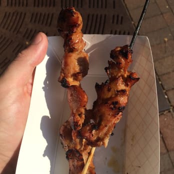 Hibachi Hut - a hand holding a skewer of meat - Food Trucks Near Me