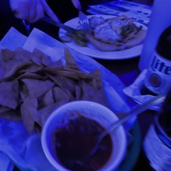 Clover’s Bar & Grill - Homemade chips and salsa - with a chicken cheesesteak in the background.