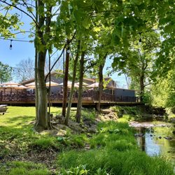Colebrook Tavern - Creekside view, looking back towards the deck & restaurant; cornhole & fire pits in open grassy area on left