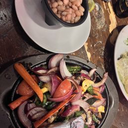 Veggie fajitas. Corn tortillas are in the foil. Beans on the side.