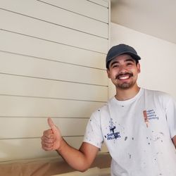 Puget Sound Quality Painting - Owner Ricardo Anaya-Hernandez giving a thumbs up in front of an over-mantel fireplace panel.