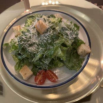 Taylor Meal Prep - Caesar salad - A Caesar salad featuring romaine lettuce, cherry tomato halves, croutons, and grated cheese served on a white plate with a blue rim. - Food Delivery Services Near Me - Austin, Texas