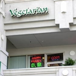 Happy Family Restaurant - There's a neon sign for the name of the restaurant next to the door. The restaurant is on the second floor.