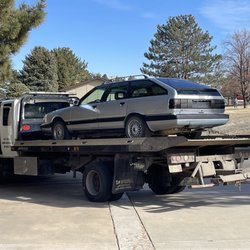 285 Towing - A tow truck towing a vintage Audi.