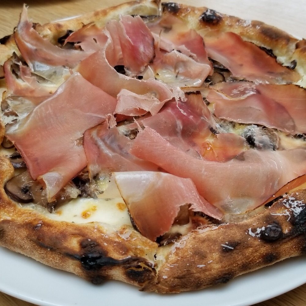 JOSS - a pizza on a white plate on a wooden table - Pizza Near Me - Vancouver, British Columbia JOSS - a pizza on a white plate on a wooden table - Pizza Near Me - Vancouver, British Columbia