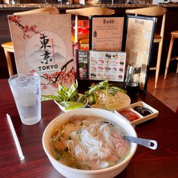 a bowl of soup and a plate of rice noodles