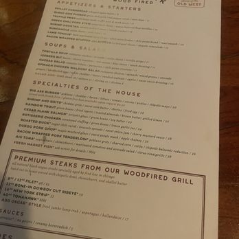 Roaring Fork - Menu - The menu from Roaring Fork restaurant displays a variety of wood-fired American cuisine options, including appetizers, salads, soups, and specialty steaks. It features dishes like shrimp cocktail, green chile mac and cheese, and a selection of premium steaks from their wood-fired grill. The menu also includes detailed descriptions of each dish, prices, and a section dedicated to premium steaks with specific cuts and cooking styles. The design emphasizes a rustic, wood-fired theme consistent with the restaurant's branding. - American Near Me - Austin, Texas