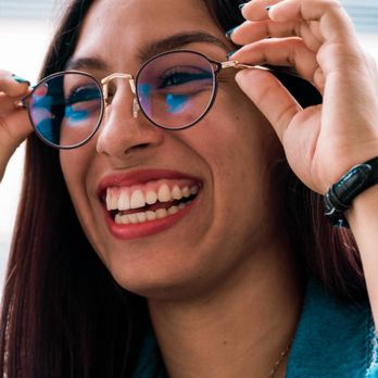 VC Vision - A woman holds a new pair of eyeglasses to her face. At VC Vision, your choice of frames, from affordable to top-end luxury options. - Eyewear & Opticians Near Me - Fort Worth, Texas VC Vision - A woman holds a new pair of eyeglasses to her face. At VC Vision, your choice of frames, from affordable to top-end luxury options. - Eyewear & Opticians Near Me - Fort Worth, Texas