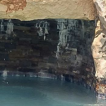 Brenner Pools & Renovations - Original calcium build up under the grotto (prior to removal) - Pool & Hot Tub Service Near Me