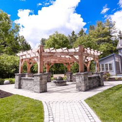 Phillips Lawn & Landscape - Pergola entertaining with built-in firepit, swinging chair, and globe fountain.