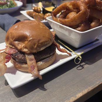 True West - Burger with bacon, and a side of onion rings. - Breweries Near Me - Acton, Massachusetts True West - Burger with bacon, and a side of onion rings. - Breweries Near Me - Acton, Massachusetts