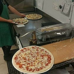 The Local Take and Bake Pizzeria - Pizza production in progress.
