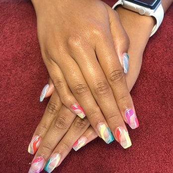 Anna's Nails - the finished product of my fill in with gel - Hands with multicolored, marbled gel nails are placed on a red textured surface, with one hand overlapping the other. The person wears a smartwatch on their wrist. - Nail Salons Near Me - Silver Spring, Maryland