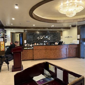 Royal Buffet - Reception area. - Reception area of Royal Buffet featuring a chandelier, a curved front desk, and an entrance with glass doors. A staff member is seated at the desk. - Buffets Near Me - Hoffman Estates, Illinois