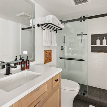 McSwain Builders - Spa-like bathroom featuring black fixtures, modern glass shower enclosure, custom wood vanity, and white subway tile for a timeless yet cont - General Contractors Near Me - Glenwood Springs, Colorado McSwain Builders - Spa-like bathroom featuring black fixtures, modern glass shower enclosure, custom wood vanity, and white subway tile for a timeless yet cont - General Contractors Near Me - Glenwood Springs, Colorado