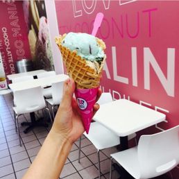 a hand holding a cone of ice cream