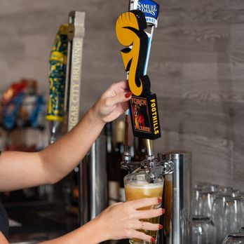 Brookfields Indoor Golf & Lounge - a woman pouring a beer - Bars Near Me - Wake Forest, North Carolina