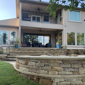 Landshapes - a house with a stone wall and patio - General Contractors Near Me Landshapes - a house with a stone wall and patio - General Contractors Near Me