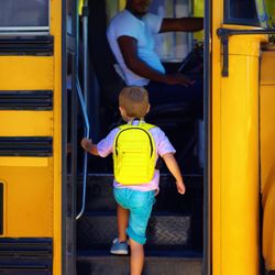 Prime Time Bus - A boy is getting on a school bus.