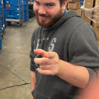 Food Lion - a man in a warehouse holding a donut - Grocery Near Me - Pasadena, Maryland