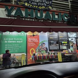 Tacos Yahualica - The outside, two tables & a few chairs and the "hole" in the wall where the cook is busy cooking