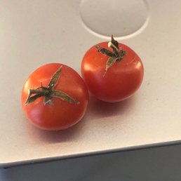 two tomatoes on a white surface two tomatoes on a white surface