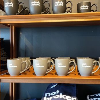 Bitty & Beau’s Coffee - a shelf of mugs and t - shirts - Coffee & Tea Near Me - Annapolis, Maryland