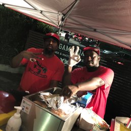 two men at a food stand two men at a food stand