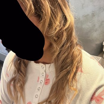 Drybar - Back Bay - This is a joke - A woman with long, wavy, light brown hair is taking a selfie, wearing a white top with pink flamingo patterns, in a room with gray walls. - Blow Dry/Out Services Near Me - Boston, Massachusetts