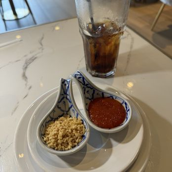 Charm Kitchen & Bar - Peanuts and Sriracha sauce in cute little servers that came with my meal. - Thai Near Me - The Woodlands, Texas Charm Kitchen & Bar - Peanuts and Sriracha sauce in cute little servers that came with my meal. - Thai Near Me - The Woodlands, Texas