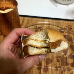 a hand holding a half eaten sandwich