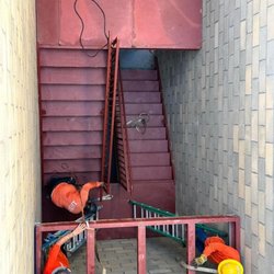 Custom Welding by Law - Our crew installing primer-coated stairs.