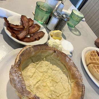 The Original Pancake House - Dutch Baby with a side of thick cut bacon. - Pancakes Near Me - La Grange, Illinois The Original Pancake House - Dutch Baby with a side of thick cut bacon. - Pancakes Near Me - La Grange, Illinois