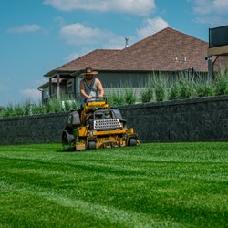Yardworx Lawn and Landscape - Freshly striped lawn below a retaining wall after weekly mowing in Lincoln, NE by Yardworx Lawn and Landscape