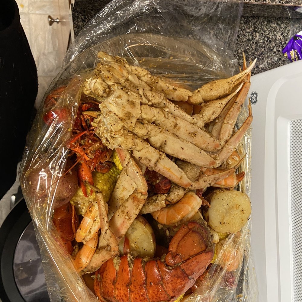 crab legs, potatoes, corn, and potatoes in a plastic bag