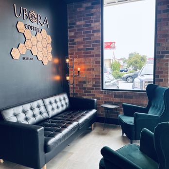 Commander Coffee - Seating area with velvet green chairs, long couch, with windows mear entrance. - Coffee Roasteries Near Me - Augusta, Georgia