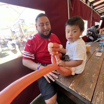 Oogubi - Elijah holding a monkey balloon and daddy Julio - Party & Event Planning Near Me