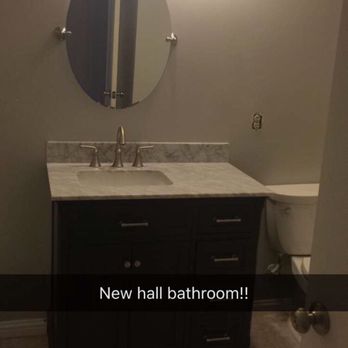 JW Construction - a bathroom with a sink and mirror - General Contractors Near Me