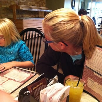 The Brickyard - a woman sitting at a table with two children - Pubs Near Me - Stanton, Michigan