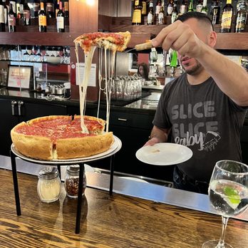 Giordano's - a man serving a pizza - Pizza Near Me - Chicago, Illinois