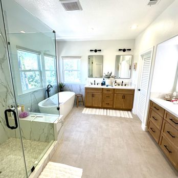 Marblehead Residential Remodeling - Luxurious bathroom with a frameless shower door, freestanding tub, and dual sinks with warm wood cabinets. - General Contractors Near Me Marblehead Residential Remodeling - Luxurious bathroom with a frameless shower door, freestanding tub, and dual sinks with warm wood cabinets. - General Contractors Near Me