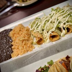 Sylvia's Kitchen - BEEF FLAUTAS WITH LETTUCE, QUESO FRESCO AND SOUR CREAM, REFRIED BLACK BEANS AND RICE.