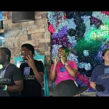 Just Brunch Breakfast Bar - Staff singing celebration songs in front of picture backdrop with Relax its Just Brunch sign. - Breakfast & Brunch Near Me - Duluth, Georgia