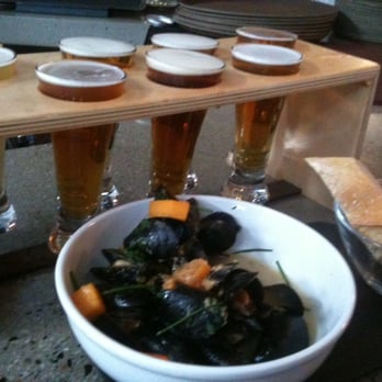 When Pigs Fly Pizzeria - Mussels and the Beer Sampler!  Choose 7 samples of yummy beer!  Double Happiness!  Sop up the tasty broth with the crusty bread. - Pizza Near Me - Kittery, Maine
