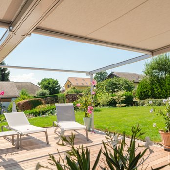 SRIZ Sales & Contracting - a view of a patio with chairs and a table - Awnings Near Me SRIZ Sales & Contracting - a view of a patio with chairs and a table - Awnings Near Me