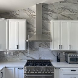 a kitchen with white cabinets and stainless steel appliances